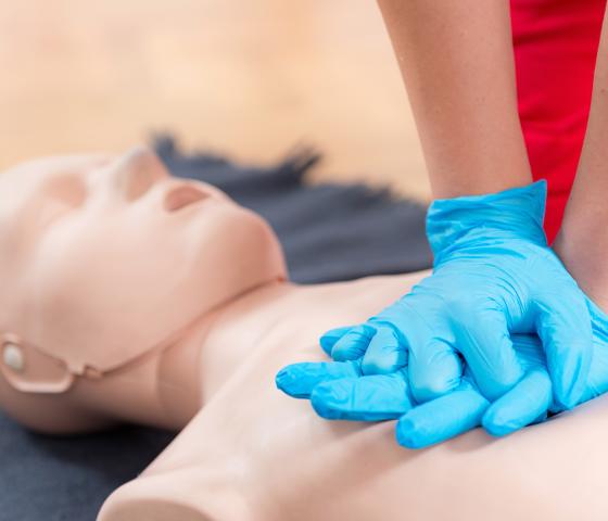 person performing chest compressions on a dummy