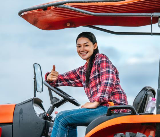 person on a tractor giving a thumbs up